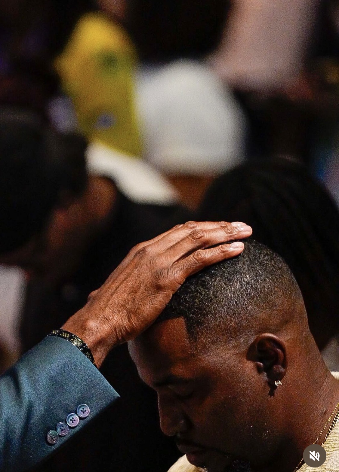 A hand resting on Brandon's head during a moment of prayer and reflection